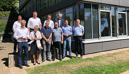 Die Beteiligten an dem Solarprojekt stehen für das Gruppenfoto vor dem Schulgebäude.