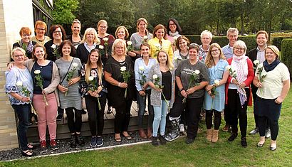 Gruppenbild mit 22 Erzieherinnen, die jeweils eine weiße Rose in der Hand halten.