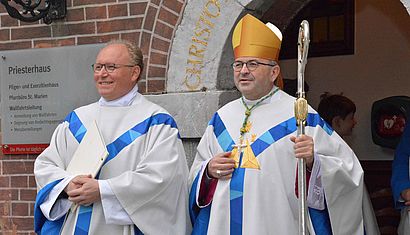 Wallfahrtsrektor Gregor Kauling und Bischof Harrie Smeets (von links) stehen vor dem Einzug in die Basilika an der Pforte des Priesterhauses in Kevelaer. 