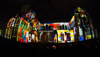 Der St.-Paulus-Dom bei Nacht wird bunt angestrahlt