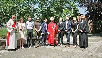 Weihbischof em. Geerlings steht auf dem Schulhof zwischen Schülerinnen und Schülern sowie Schulseelsorger Johannes Gröger (links) und die evangelische Pfarrerin Dr. Petra Gosda.