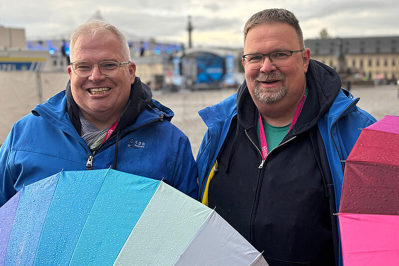 Besucher des Katholikentags mit Regenschirm