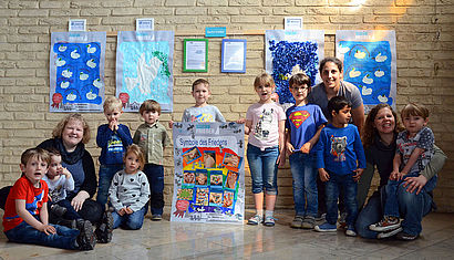 Die Kinder der Kita sitzen vor den Friedensurkunden in der Kirche. 