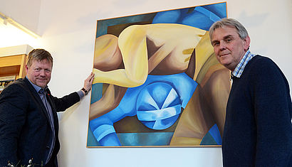 Rupert König, Leiter des Kirchenfoyers, und der Künstler Pfarrer Hans Günter Voß hängen ein Bild auf. 