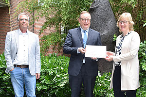Vera Brox überreicht Christoph Bickmann eine Festschrift. Links daneben steht Meinolf Bömelburg. Vera Brox überreicht Christoph Bickmann eine Festschrift. Links daneben steht Meinolf Bömelburg.