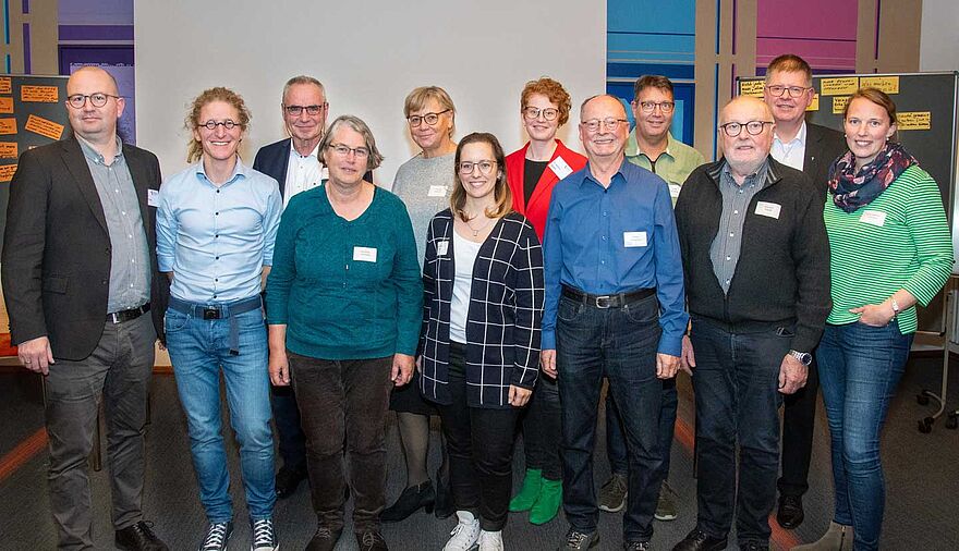 Mehrere Frauen und Männer stehen zu einem Gruppenbild zusammen.