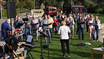 Ein Chor steht auf einer Wiese.