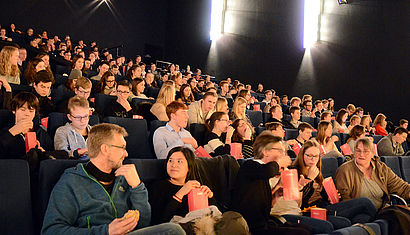 Jugendliche sitzen im Kinosaal.