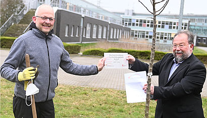 Thomas Kamp-Deister überreicht Urkunde und Plakette „Ökofaire Einrichtung Familienbildungsstätte Bocholt Level II“ an Ulrik Störzer 