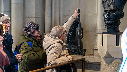 Beim Kreuzweg von Bert Gerresheim haben die Teilnehmerinnen die Möglichkeit, die Bronzefiguren im Domumgang zu ertasten.