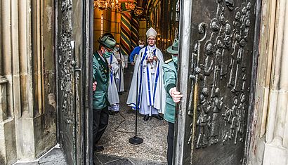 Zwei Schützen schließen das Pilgerportal, dahinter ist Weihbischof Borsch zu erkennen.