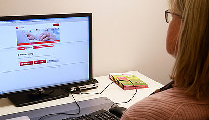 Eine EFL-Beraterin sitzt vor ihrem Computer. 