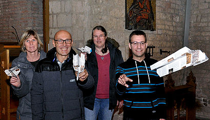 In der Kirche stehen Heike und Ludger Hufschmidt, Elisabeth Pasedag und Markus van Briel. Die ersten drei halten einen Papierflieger in der Hand, ein vierter Flieger schwebt nach rechts aus dem Bild heraus.