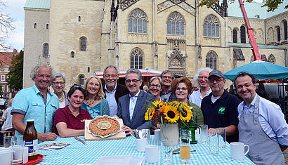 Die Initiatoren feiern mit einem Geburtstagskuchen das Jubiläum des ökologischen Bauernmarkts.