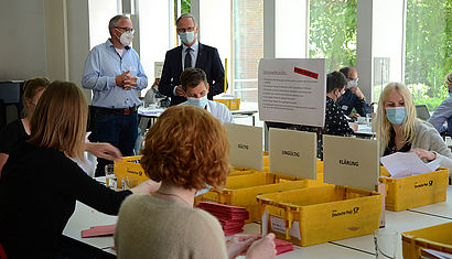 Generalvikar Dr. Klaus Winterkamp steht hinter einem Tisch, an dem die Wahlzettel geprüft werden. Neben ihm Ulrich Richartz, Vorsitzender des Wahlauschusses.