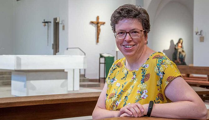 Eine Frau sitzt in einer Kirche.