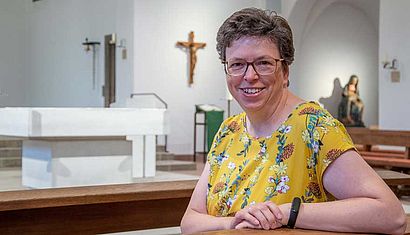 Eine Frau sitzt in einer Kirche.