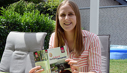 Lara Bender liest einen Reiseführer über Tansania.