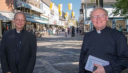 Die Pfarrer Andreas Poorten (links) und Gregor Kauling stehen in der Kevelaerer Innenstadt.