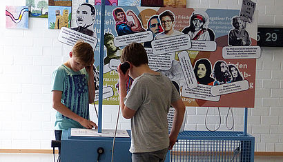 Zwei Schüler besichtigen die Ausstellung "Frieden machen".