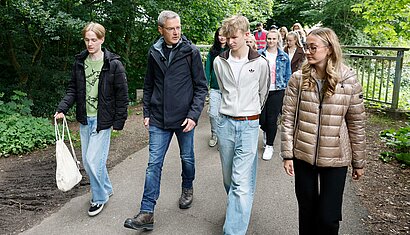 Der Bischof spricht beim Pilgern mit jungen Menschen.