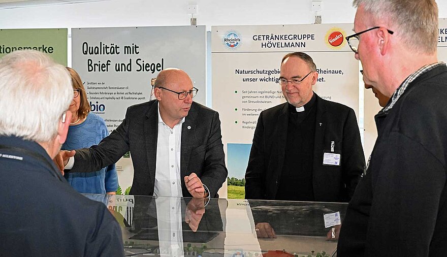 Mehrere Personen stehen in einem Raum an einem Schaukasten.