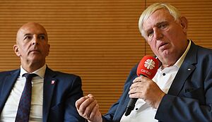 Karl-Josef Laumann spricht in ein Mikrofon. Neben ihm sitzt Dr. Georg Lunemann.