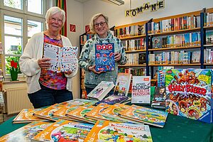 Gertrud Langenberg-Vieting und Anne Landwehr engagieren sich in der Uedemer Bücherei. Auf dem Tisch im Eingangsbereich präsentieren sie die neusten Werke. 