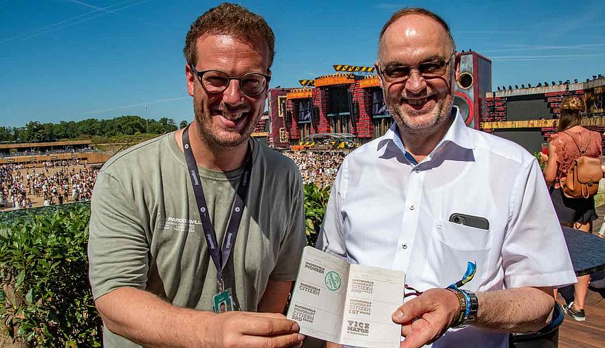 Zwei Männer stehen auf einem Festivalgelände.