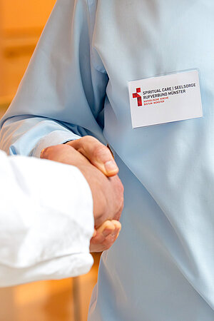 Auf dem Bild ist ein Namensschild zu sehen, dass den Schriftzug "Spiritual Care / Seelsorge: Rufverbund Münster" Auf dem Bild ist ein Namensschild zu sehen, dass den Schriftzug "Spiritual Care / Seelsorge: Rufverbund Münster"