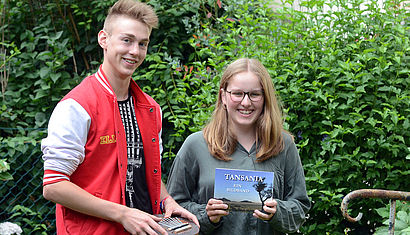 Elias Homberg und Emma Brandt stehen im Garten. 