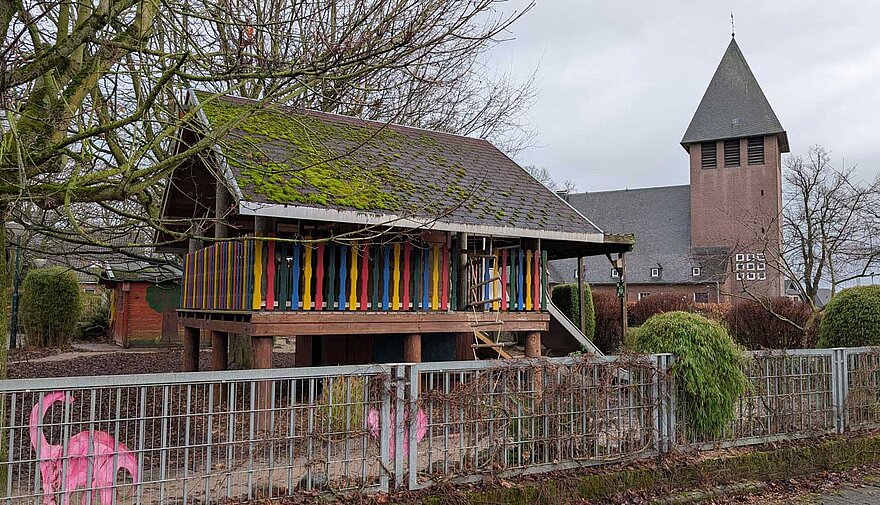 Vor der Kirche von Niedermörmter steht ein Spielgerüst.
