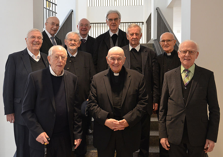 Pfarrer em. Dr. Wilfried Hagemann, Pfarrer em. Antonius Lendermann, Pfarrer em. Clemens Roer, Pfarrer em. Karl Bertrand, Pfarrdechant em. und Propst em. Gerhard Wulf, Pfarrer und Propst em. Heinrich Remfert, Bischof Dr. Felix Genn, Pfarrer i.R. Edgar Kotzur, Pfarrer em. Friedrich Hesselmann und Pfarrer em. Dr. Heinrich Valentin stehen in der Eingangshalle des Bischöflichen Priesterseminars Borromaeum.