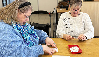 Zwei Frauen die Karten bekleben