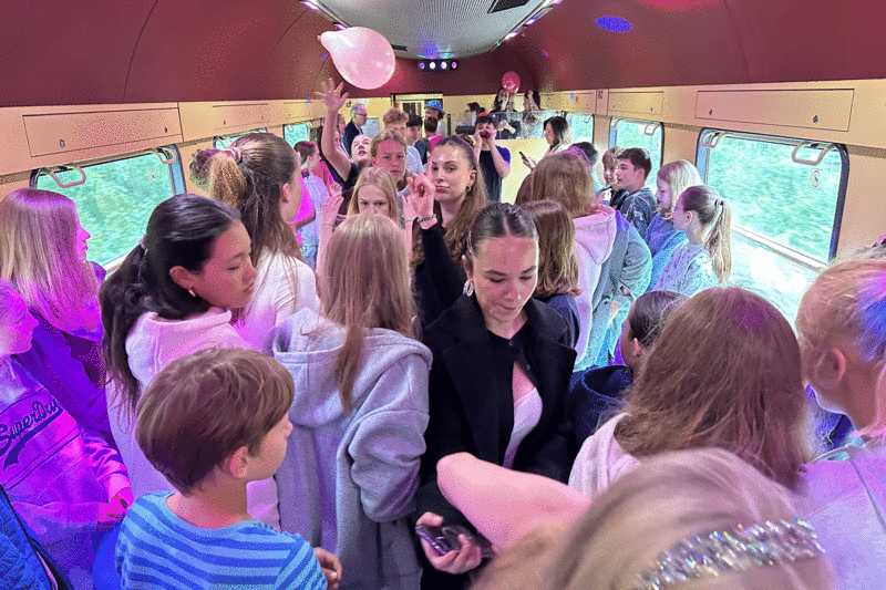 Schülerinnen und Schüler tanzen in einem Wagon in einem Partyzug.