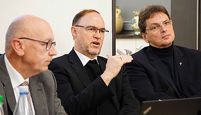 Während Weihbischof Lohmann (Mitte) redet, hören ihm Ulrich Hörsting (links) und Michael van Meerbeck interessiert zu.