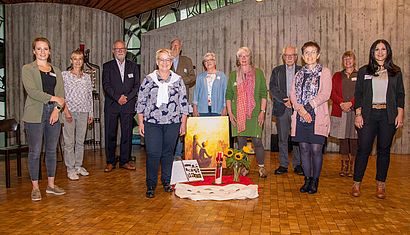 Mehrere Männer und Frauen stehen nebeneinander in einer Kapelle.