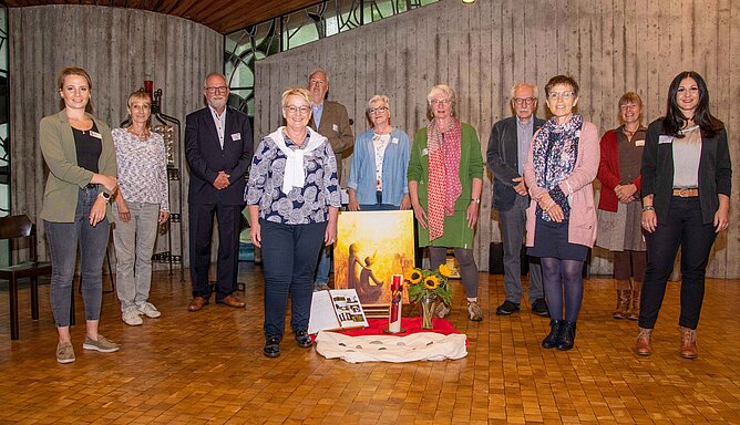 Mehrere Männer und Frauen stehen nebeneinander in einer Kapelle.