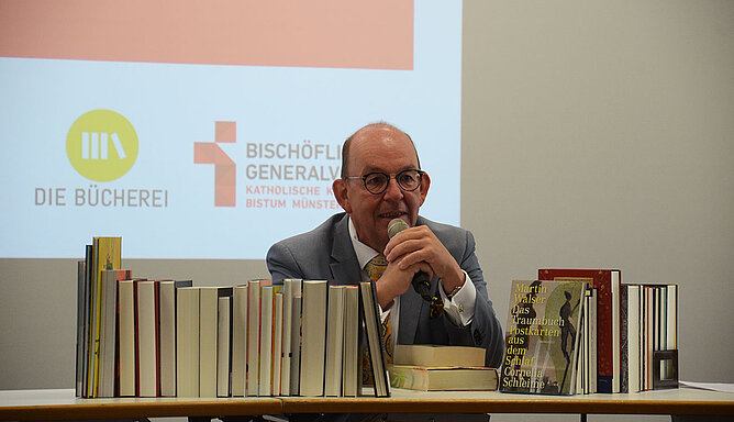 Literaturkritiker Denis Scheck hinter einem Stapel Bücher