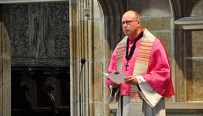 Domkapitular Stefan Sühling steht der Gemeinde zugewandt im Altarraum des Xantener Doms.