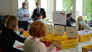 Generalvikar Dr. Klaus Winterkamp steht hinter einem Tisch, an dem die Wahlzettel geprüft werden. Neben ihm Ulrich Richartz, Vorsitzender des Wahlvorstands.