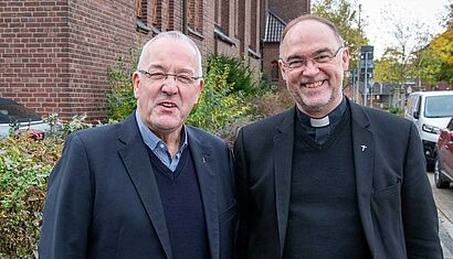 Herbert Werth und Rolf Lohmann stehen auf einem Bürgersteig.