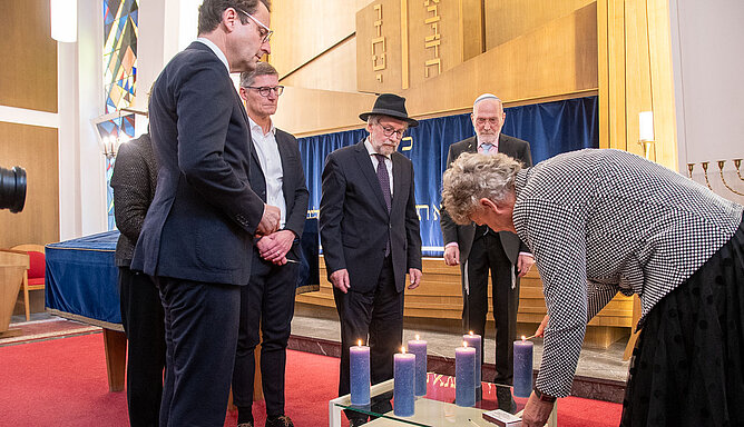 Staatsministerin a.D. Sylvia Löhrmann steht am Rednerpult in der Synagoge in Münster und gestikuliert während ihres Vortrags. 