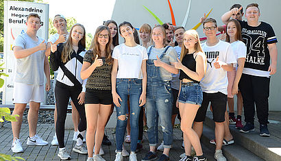 Die Schülerinnen und Schüler haben für das Gruppenfoto Migena Cela in ihre Mitte genommen.