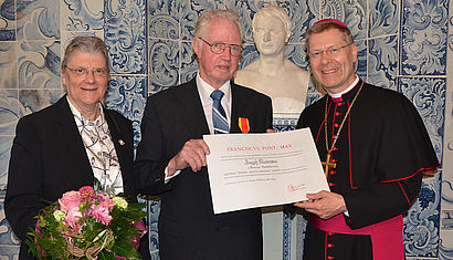 Josef Kückmann und seine Ehefrau Doris mit Weihbischof Zekorn und der Urkunde zur Verleihung des Gregorius-Ordens