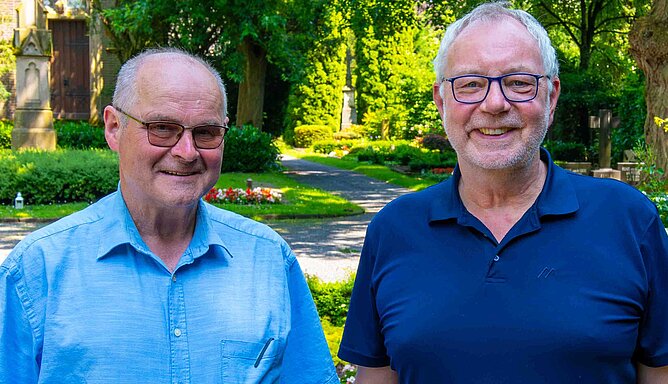 Zwei Männer stehen auf einem Friedhof