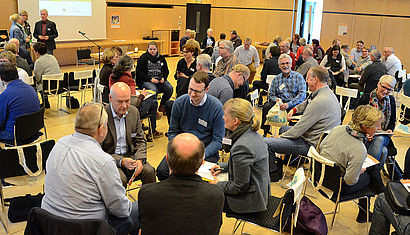 Viele Menschen sitzen in einem Saal.