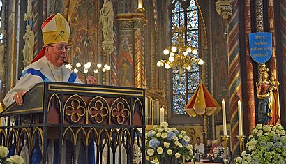 Erzbischof Jean-Claude Hollerich steht am Ambo der Marienbasilika und predigt.