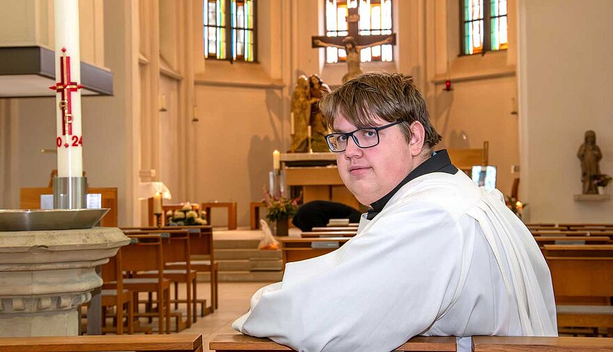 Ein Mann sitzt einer Kirchenbank