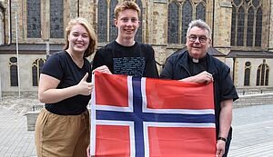 Marisa Grummich, Jannis Post und Georg Austen halten eine norwegische Flagge.